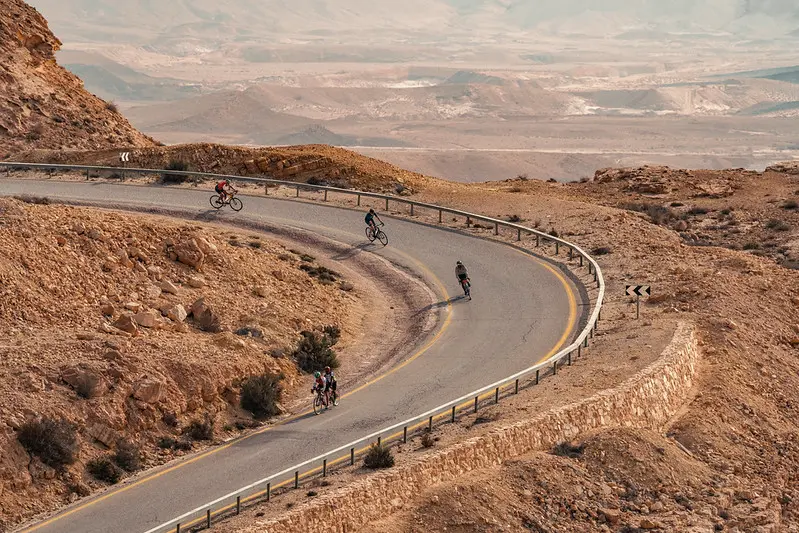 Cyclists barrel down a curve in the Negev